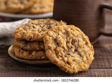 Oatmeal raisin cookies and coffee cup in background on rustic wooden table