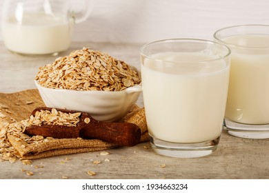 Oatmeal in a white bowl with a glass of milk on a white blue background. A healthy, nutritious morning breakfast. Oat milk. Healthy vegan non-dairy organic drink with flakes.  - Powered by Shutterstock