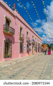 Oaxaca, Mexico - November 7, 2021 - Vertical Street Photography Of People Walking With Colonial Houses With Day Of The Dead Sculpture