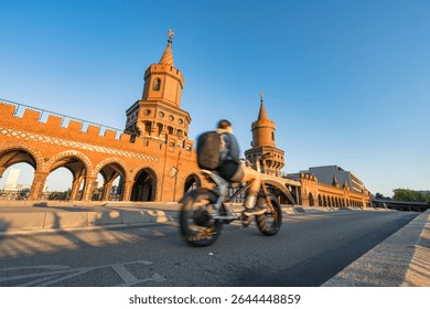Oberbaum Bridge with soft sunset light and blurry cyclist in motion in Berlin. Germany