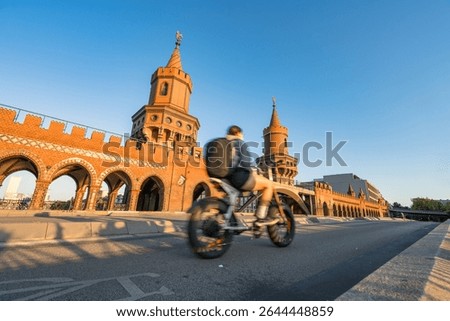 Oberbaum Bridge with soft sunset light and blurry cyclist in motion in Berlin. Germany