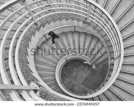 Oberhead view of a an unrecognisable man walking up a spiral staircase