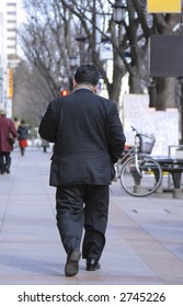 Obese Businessman Walking In A City Street.