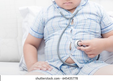 Obese fat boy check stomach by stethoscope. Tight shirt of pajamas,healthy concept