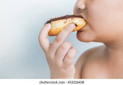 obese fat boy eat donut on gray background