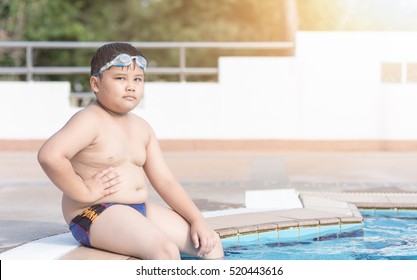 obese fat boy sitting in swimming pool, concept diet and exercise