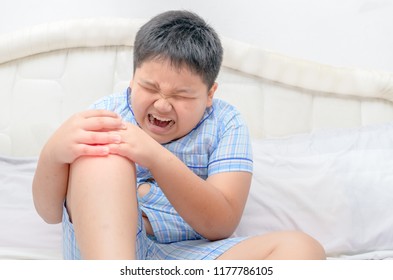 Obese Fat Boy Suffering From Knee Pain And Sit On Bed, Healthy Problem