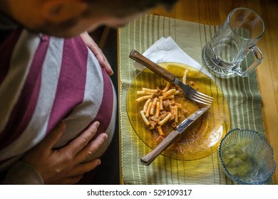 Obese Man Holding His Stomach After Eating Too Much Food