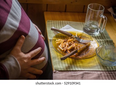 Obese Man Holding His Stomach After Eating Too Much Food