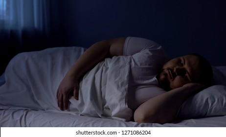 Obese Man Sleeping In Bed, Relaxing At Night On Comfortable Mattress, Rest