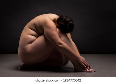 Obese nude woman doing yoga exercise. Workout concept.	