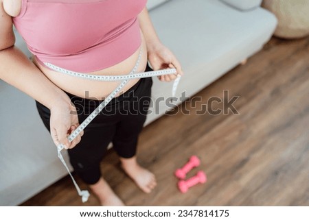 Obese Woman with fat belly in dieting concept. Overweight woman touching his fat belly and want to lose weight. Fat woman her waist with a centimeter.
Shape up healthy