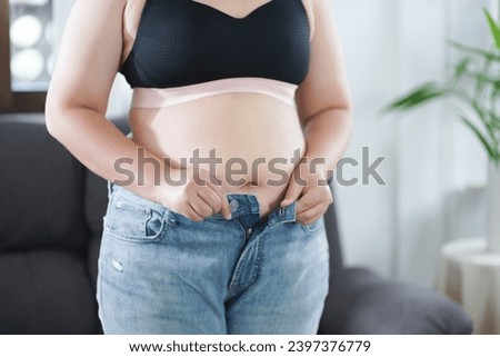 Obese Woman with fat upset about her belly. Overweight woman touching his fat belly and want to lose weight. Fat woman with tight clothing worried about weight diet lifestyle concept.