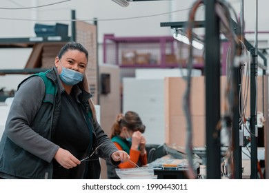 An Obese Woman Works In A Heavy Metal Factory, Wearing A Mask On Her Face Due To A Coronavirus Pandemic