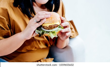 Obese Women Are Happy With Eating Hamburgers, Which Consist Of Meat, Fresh Vegetables, Breads And Cheese With White Background, To Food And Healthy Concept.