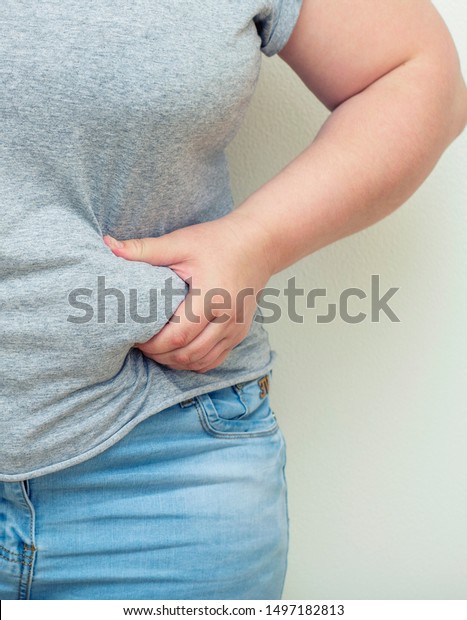 肥満 太った女性が両手で腹太りをし ショックを与えている の写真素材 今すぐ編集