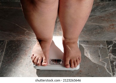 obesity and overweight, overweight woman feet on the scale, concept of obesity and bad habits