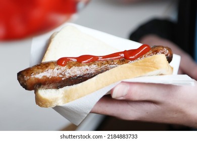 An object of beauty. The traditional family bbq favorite, the humble sausage sandwich, sausage in bread or snag sanga. A side on sausage in white bread with bright red sauce or ketchup.  - Shutterstock ID 2184883733