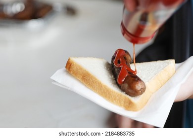An object of beauty. The traditional family bbq favorite, the humble sausage sandwich, sausage in bread or snag sanga. A side on sausage in white bread with bright red sauce or ketchup.  - Shutterstock ID 2184883735