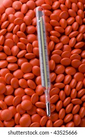 object on red - Tablets and thermometer close up on red