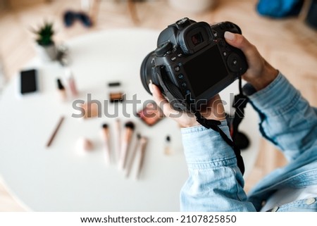 Object Photography. Unrecognizable Female Photographer Taking Photo Of Cosmetic Products On Desktop, Closeup Of Hands Holding Camera Indoors. Cropped, Selective Focus