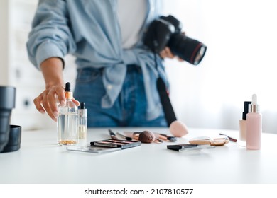 Object Photography. Unrecognizable Photographer Lady Putting Cosmetic Products On Table Making Composition And Taking Photo Of Makeup Background, Holding Camera Indoor. Selective Focus, Cropped