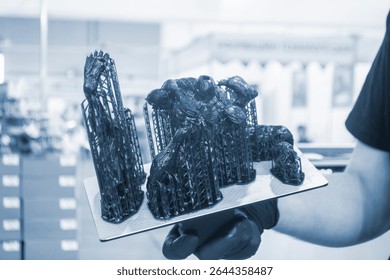 An object printed on a 3D printer from hardened rubber close-up. Model black color created on a 3D printer from hardened rubber under influence of ultraviolet light. SLA 3D printing. Stereolithography
