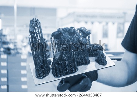 An object printed on a 3D printer from hardened rubber close-up. Model black color created on a 3D printer from hardened rubber under influence of ultraviolet light. SLA 3D printing. Stereolithography