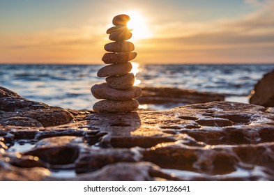 The object of the stones on the beach at sunset. Zen concept. Sunset. Silhouette of stones against the sunset sky
