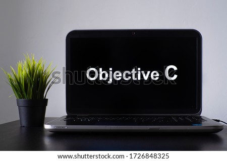 Objective C programming language. Programming training, the concept of computer courses. Laptop on the table with Objective C written on the screen
