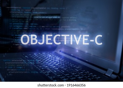 Objective-C inscription against laptop and code background. Learn programming language, computer courses, training.  - Shutterstock ID 1916466356