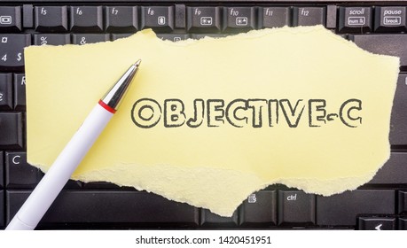 Objective-c programming language. Paper width word Objective-c and pencil on laptop keyboard