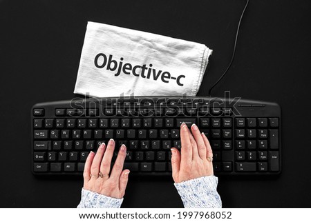 Objective-c programming language. Rag width word Objective-c and hands on pc keyboard 