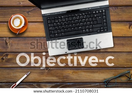 Objective-c Programming Language. Word Objective-c on wooden desk and laptop 