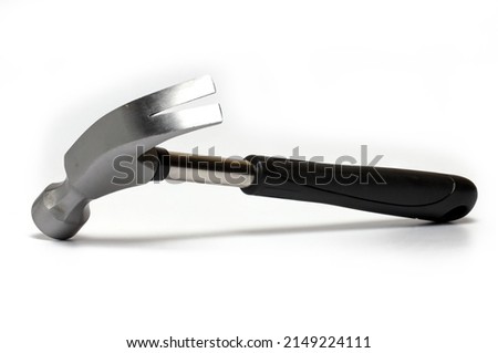 Oblique side view of metal shiny hammer with claw for pulling nails and rubber handle in black on white background