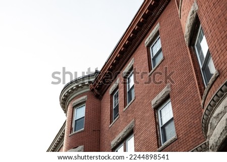 Oblique view of brick apartment building with rusticated stone window lintels  and dentil trim details, horizontal aspect