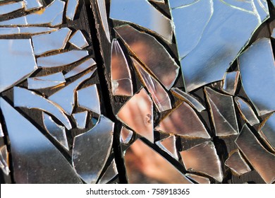 Obscured Image Of A Woman In Broken Glass Reflection