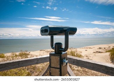 Observation deck with fixed observation binoculars. View on a sand dune and seashore