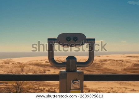 Observation deck with fixed observation binoculars. View on a sand dune and seashore