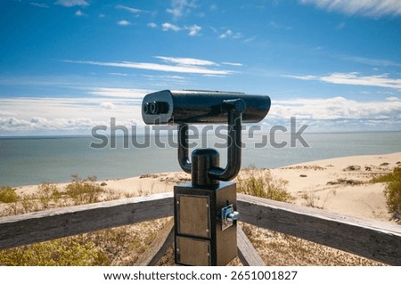 Observation deck with fixed observation binoculars. View on a sand dune and seashore
