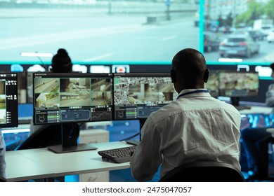 Observation room employee reviewing video surveillance footage to find illegal activity within urban traffic, big screen. African american man collecting data via CCTV radar system. - Powered by Shutterstock