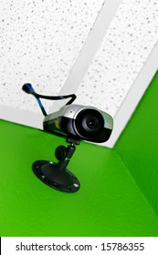 Observation and security camera is mounted on wall of bright green room.