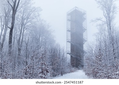 Observation tower surrounded by snow-covered trees and dense fog in a winter forest setting. Galyatető, Hungary - Powered by Shutterstock