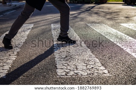Obsessive compulsive disorder, man trying not to step on the black lines of a pedestrian crossing. 
Conceptual psychological problem, OCD