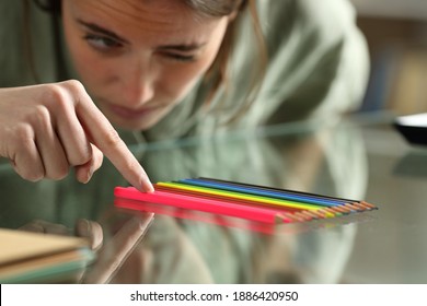 Zwangszwingende Frau, die die Stifte genau auf einem Glastisch ausrichtet