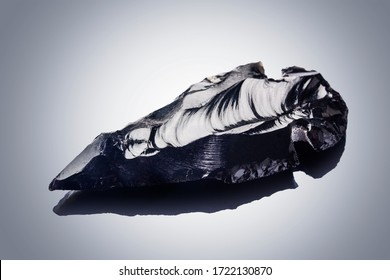 Obsidian Stone Arrowhead On Black Background With Reflection