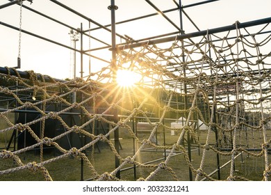 obstacle course races climbing rope net with sunset sky