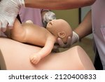Obstetrics medical team delivering baby for woman manikin with painful labor contractions at maternity clinic. Adult pushing while giving birth to child in bed with man, nurse and doctor