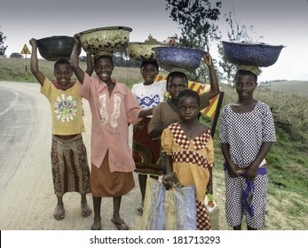 OBUDU, NIGERIA, CIRCA 2004: A happy group of unidentified young villagers carrying grain near Obudu Cattle Ranch close to the border or Cameroon and Nigeria.