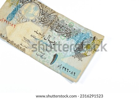 obverse side of 1 Qatari Riyal cash money currency of Qatar banknote features Ornated column, arches, sailboats, palm trees, crossed swords, vintage retro old leftover Qatar bill, selective focus